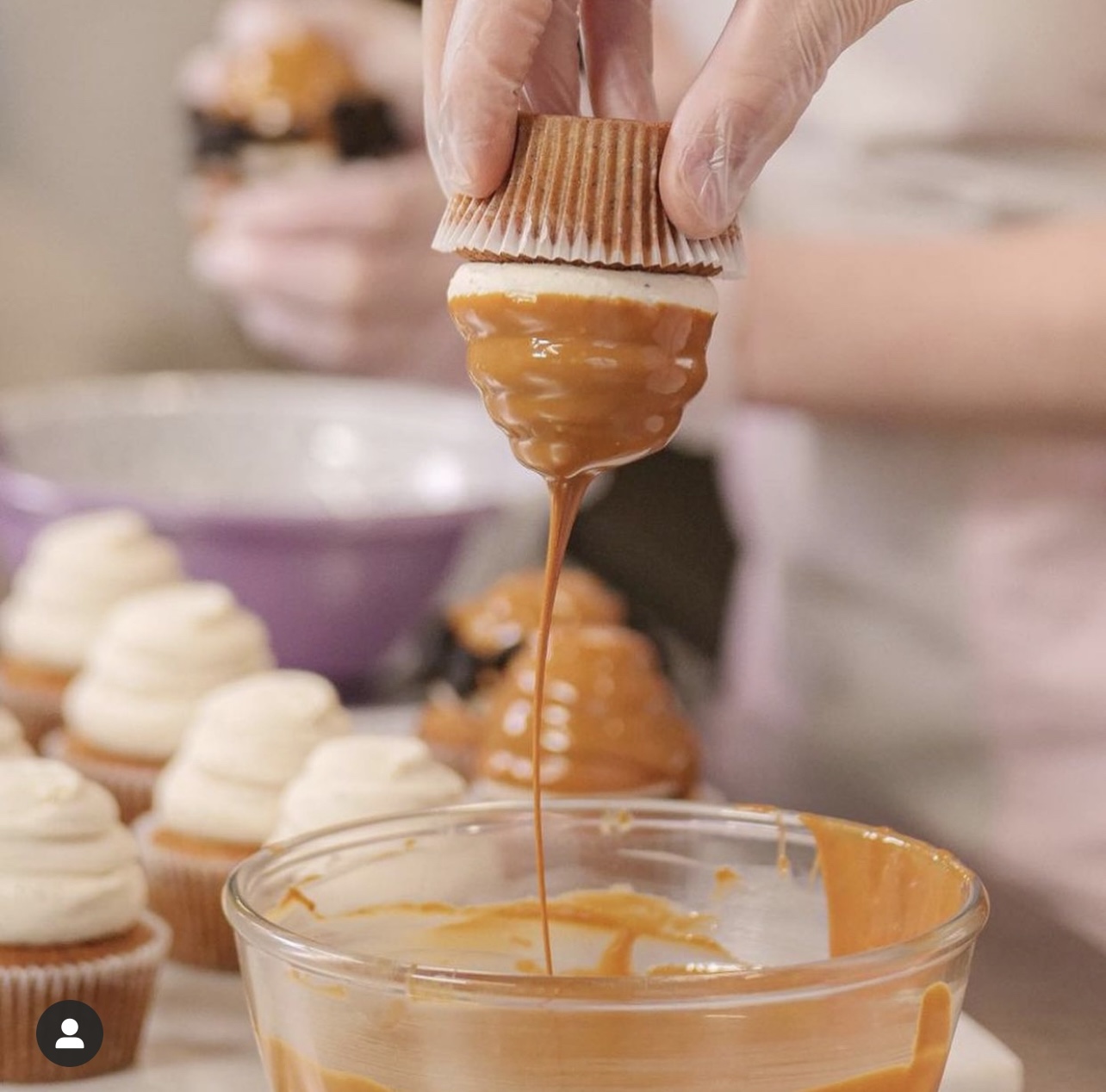 Cupcake being dipped in caramel.