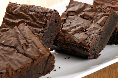 Four slices of chocolate fudge brownineson a plate.